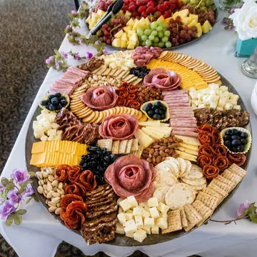 Handcrafted charcuterie and cheese board with salami roses, crackers, and fresh fruit